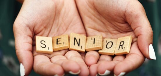 Senior dice on person's palm