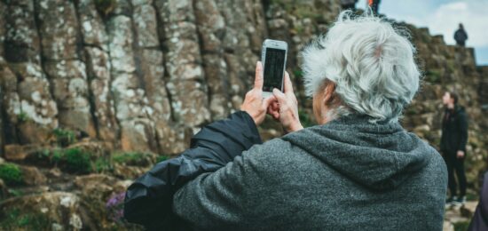 man in black hoodie holding smartphone