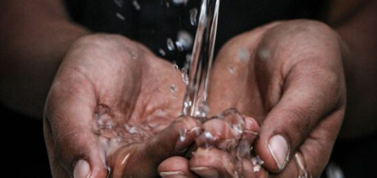 pouring water on person's hands